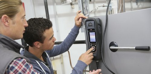 Zwei Anlagenmechaniker die eine Anlage mit einem Messgerät prüfen
